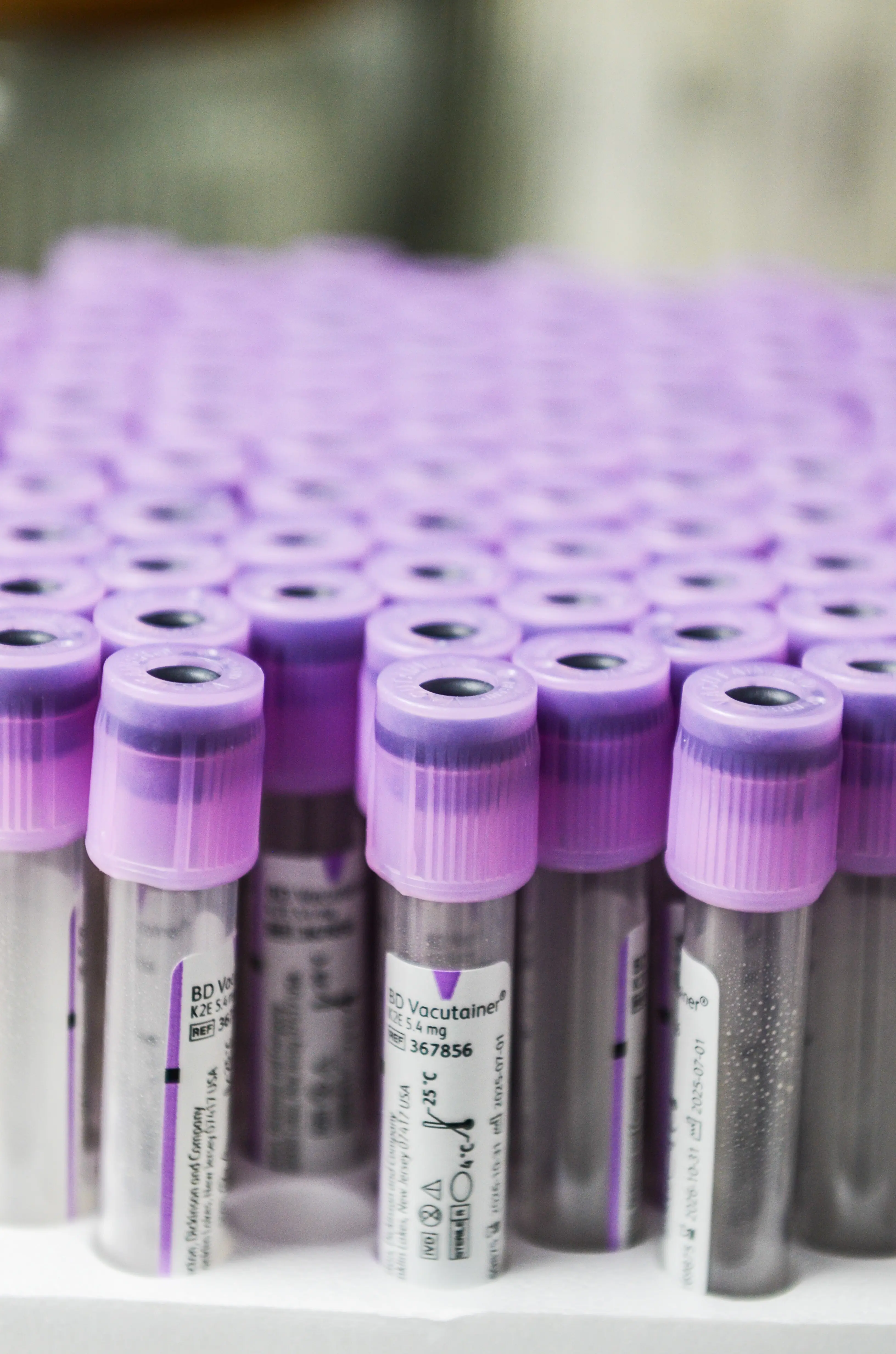 a tray of test tubes with purple cover and white label