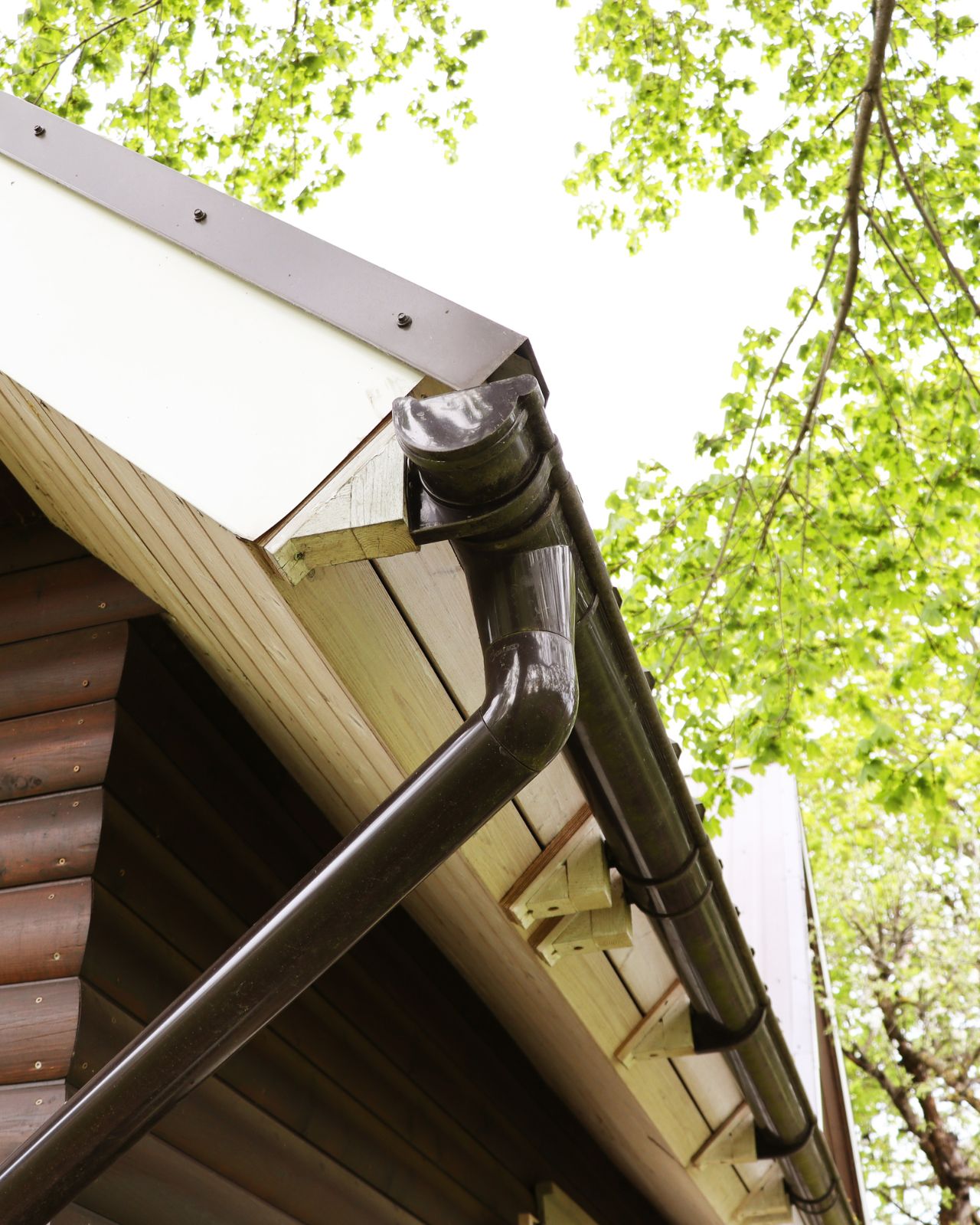 Half round gutter system installed along roof edge with round downspout on a residential home