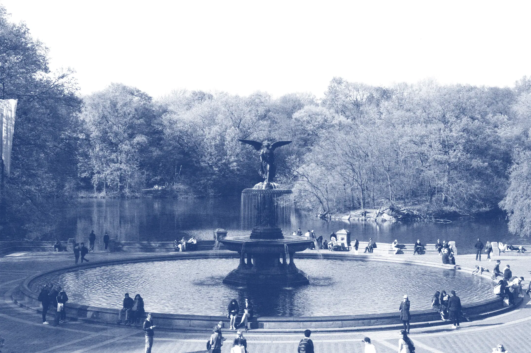 A fountain surrounded by people in a park.