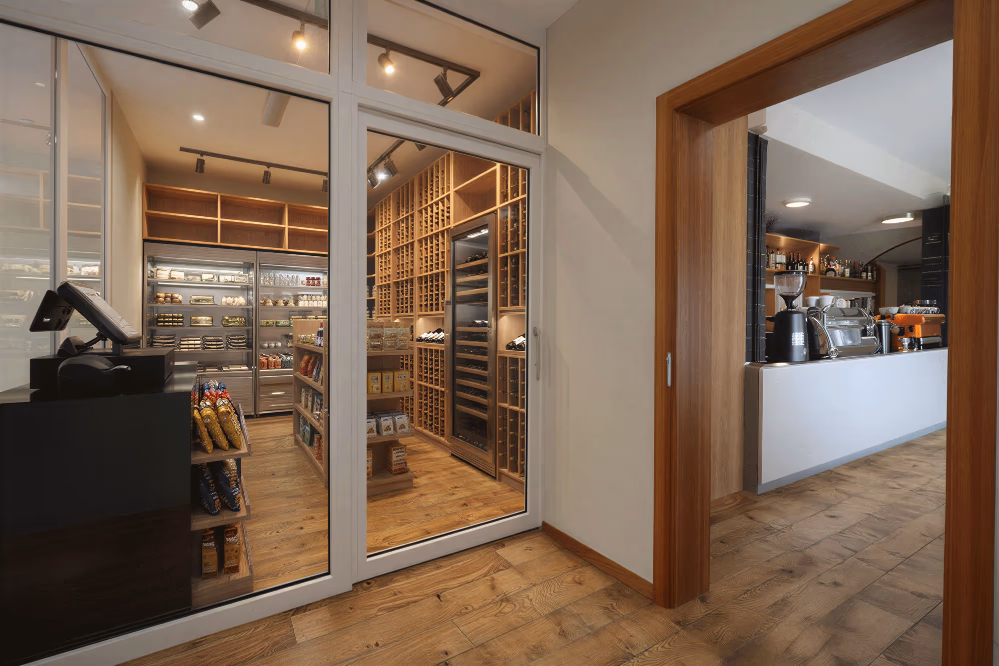Blick aus einem gemütlichen Hotelzimmer mit Doppelbett und gepolsterten Kissen auf herbstliche Berglandschaft mit Tannen und traditionellen Häusern.