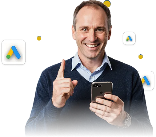Usměvavý muž držící chytrý telefon a ukazující prstem nahoru, kolem něho se objevují ikony Google Ads.