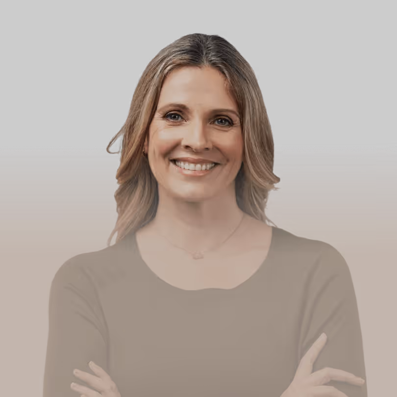 Lächelnde Frau mit langen, blonden Haaren vor schwarzem Hintergrund, Arme verschränkt.