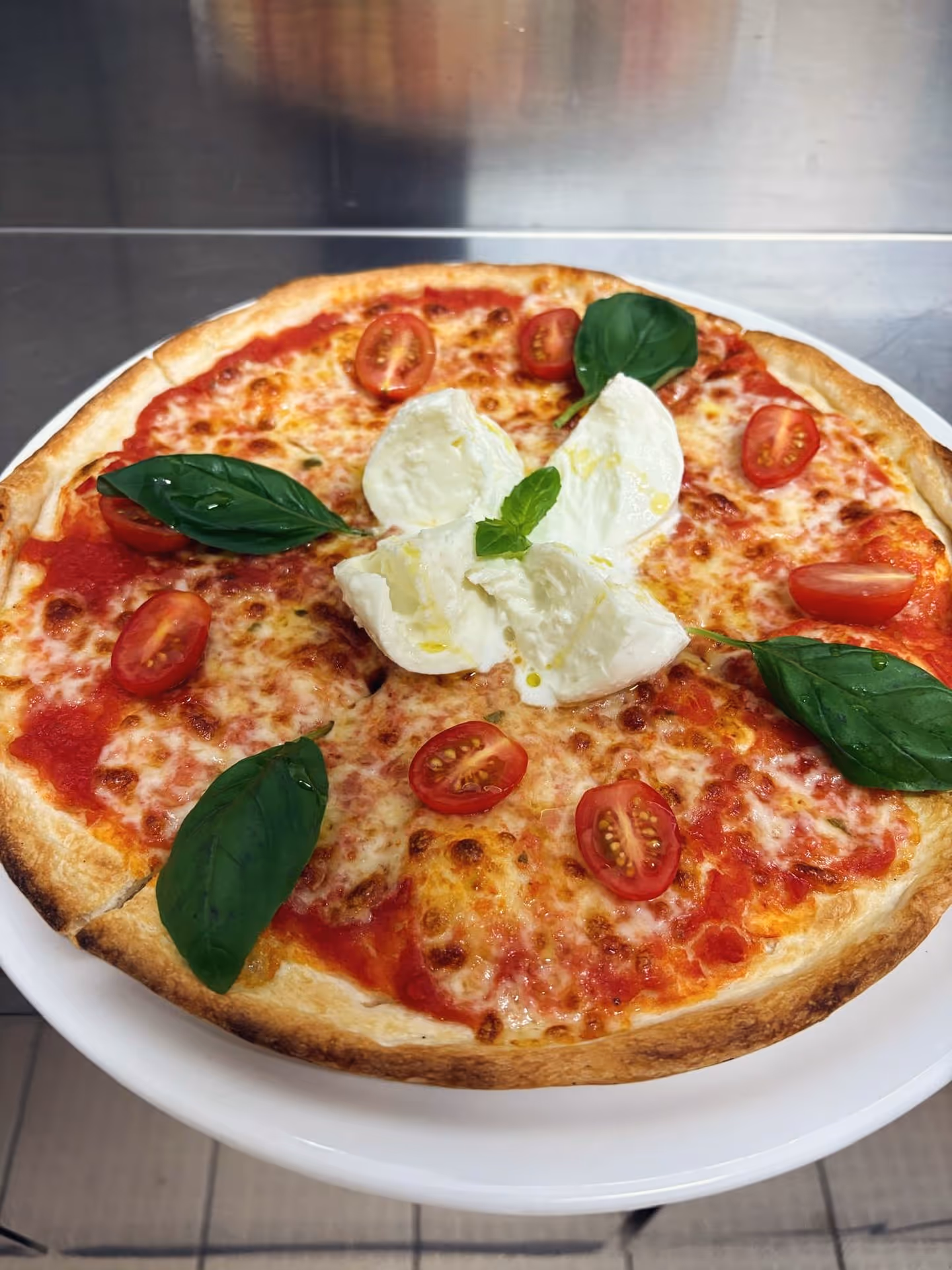 pizzapastaconamore - Ein Stück Italien auf deinem Teller – unsere Pizza mit frischer Büffelmozzarella, Kirschtomaten und Basilikum. Einfach Liebe auf den ersten Biss! 