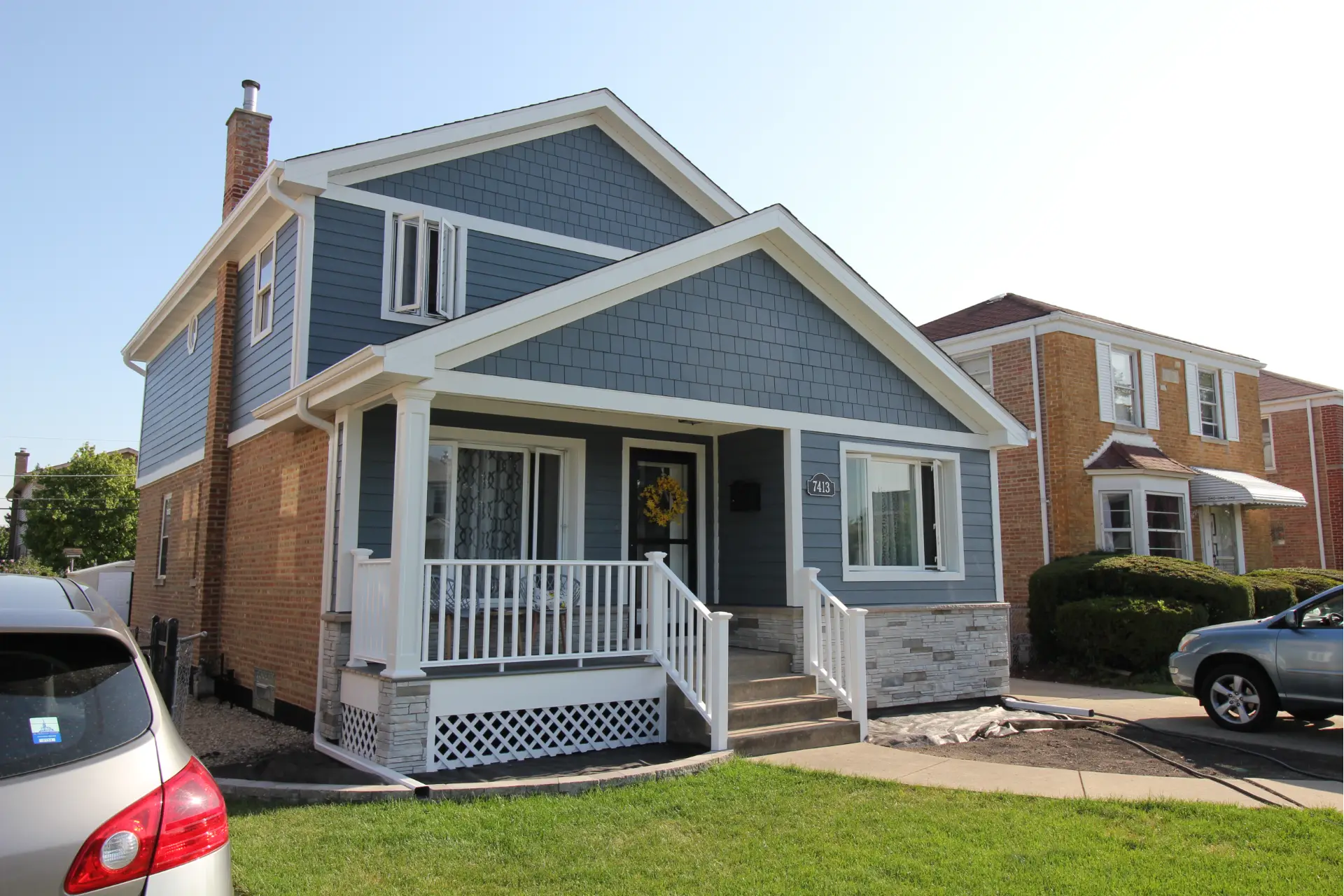 Blue home exterior with new siding, trim, and windows installed by All About Exteriors for improved curb appeal and durability.