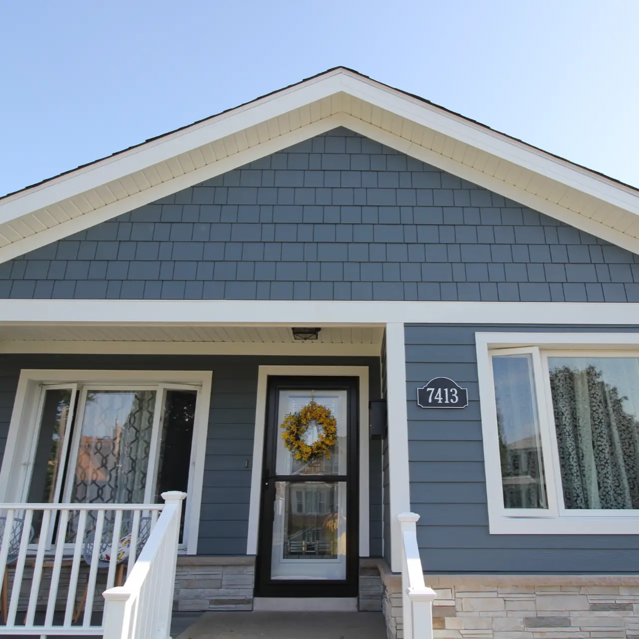 Blue home exterior with new siding, trim, and energy-efficient windows installed by All About Exteriors team in Chicago area