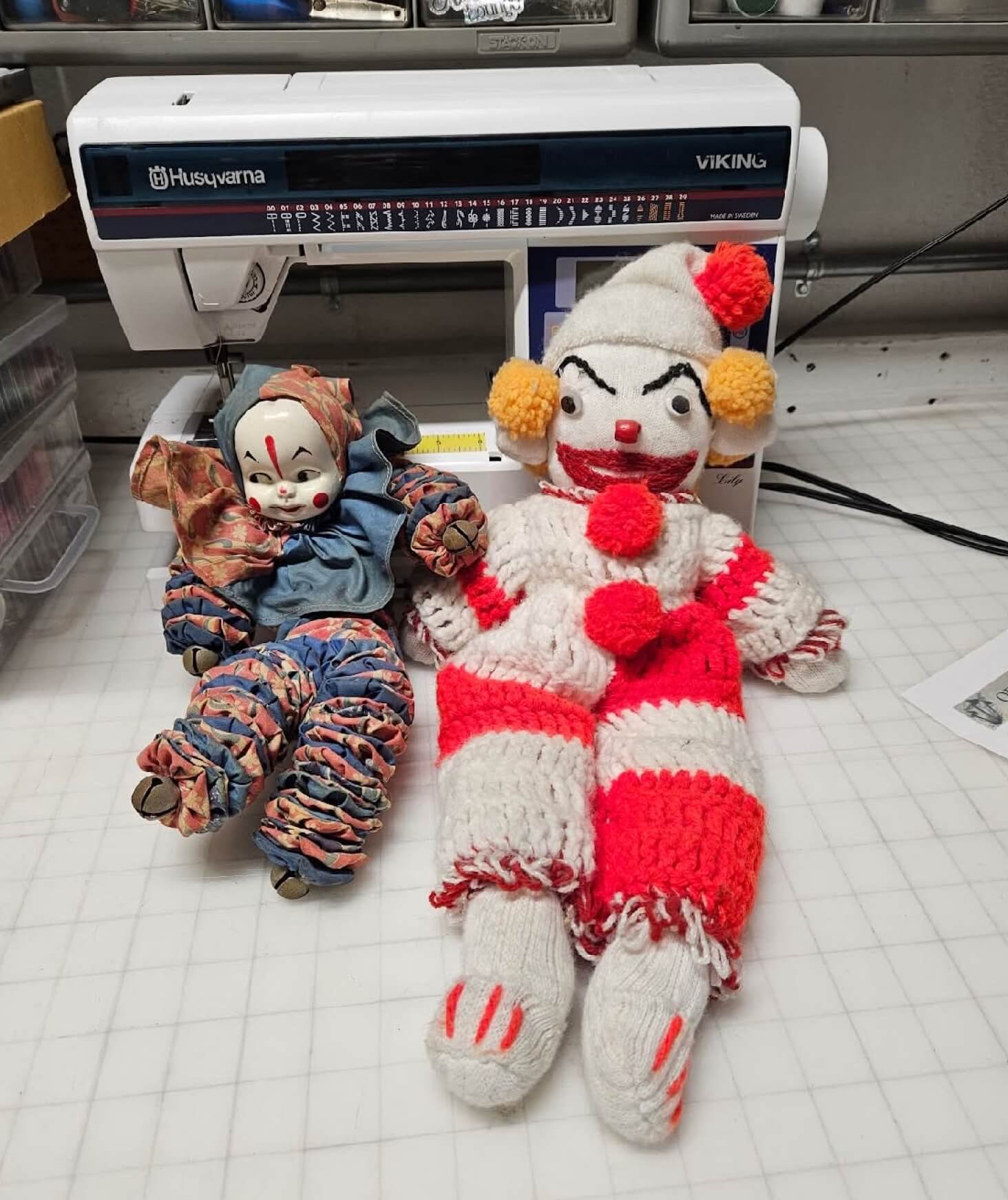 Two crocheted clowns on the ground.