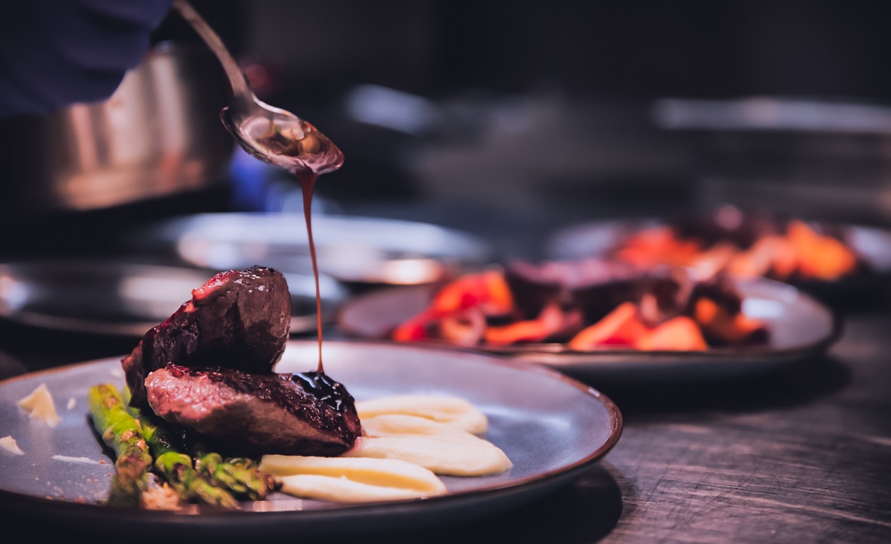 steak being plated by a chef
