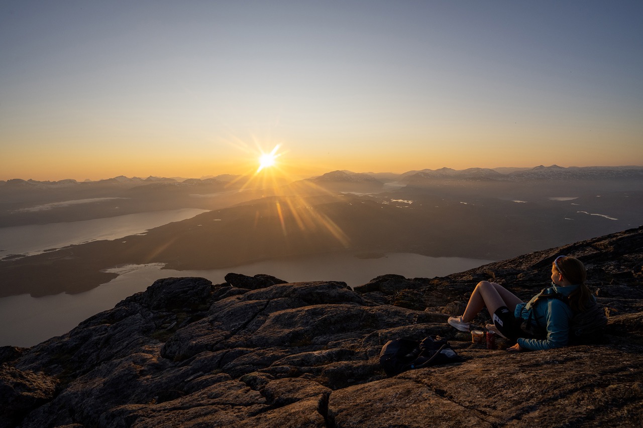 person watching the midnight sun from a mountain