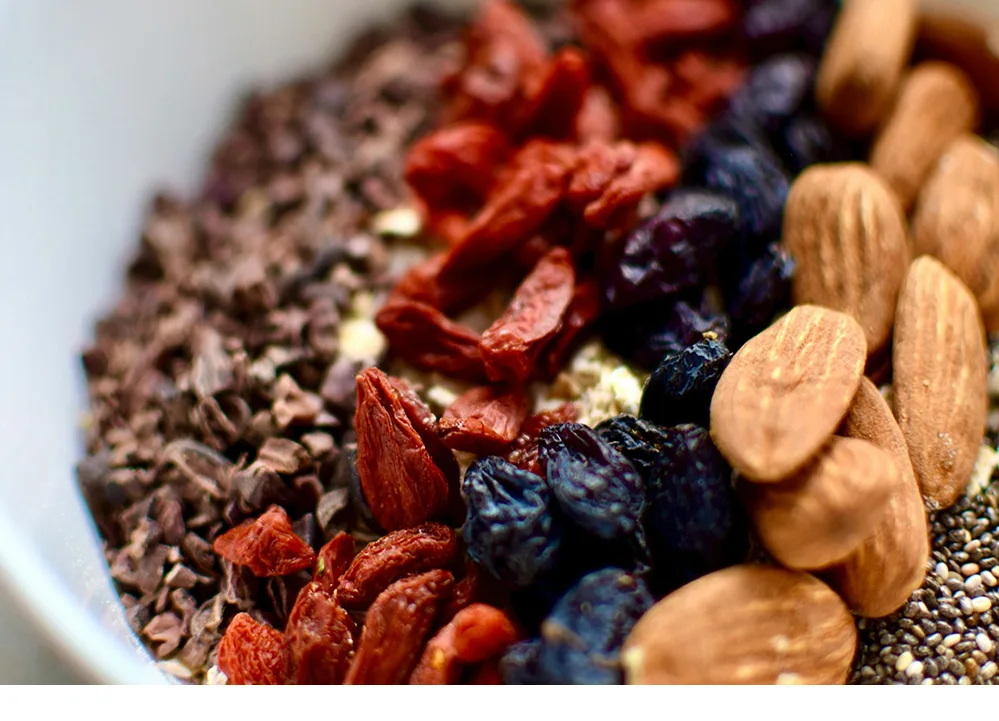 Bol de céréales, fruits, amandes et raisins secs.