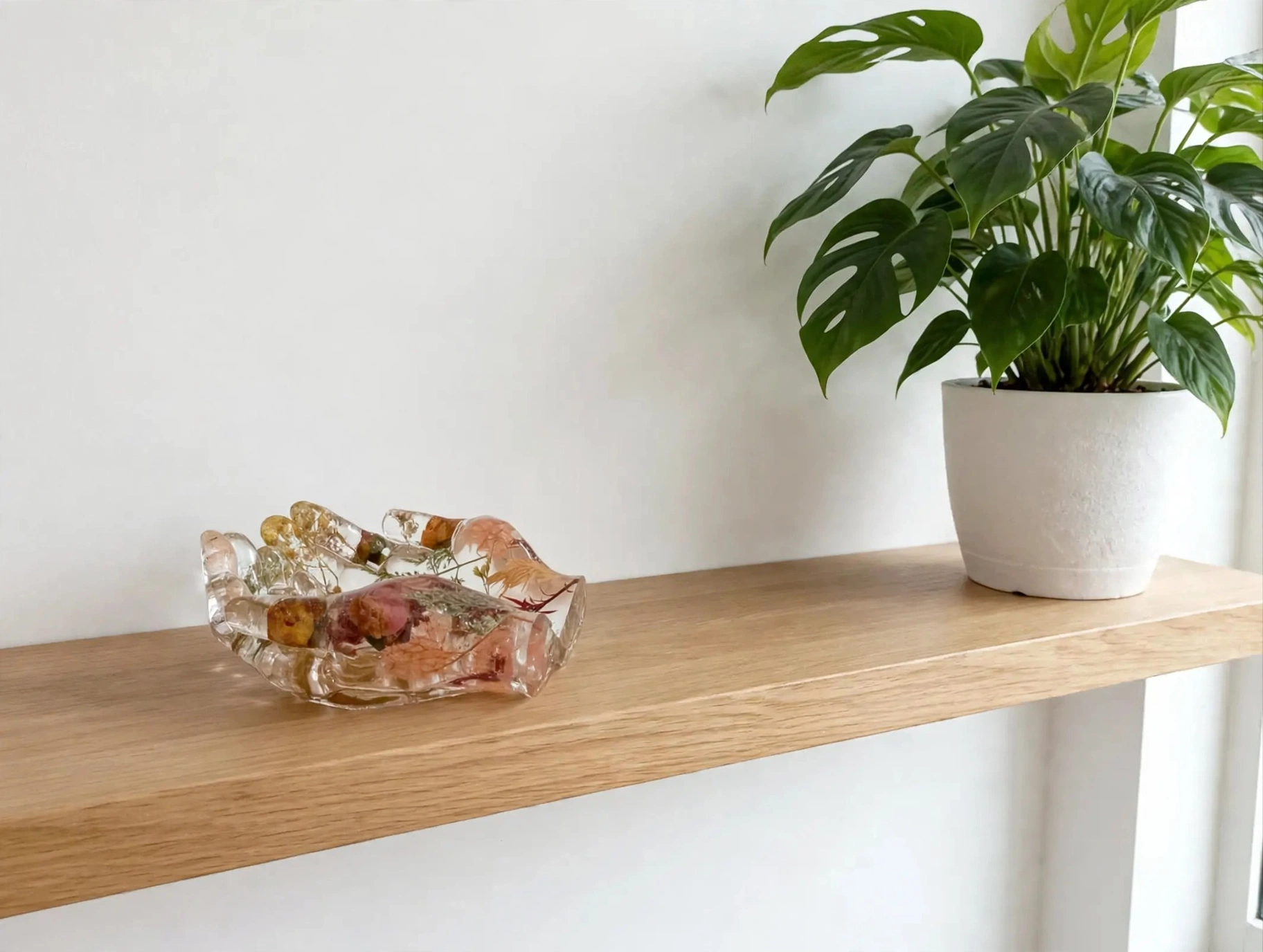 Bandeja joyero manos de resina con flores secas sobre estanteria de madera junto a planta monstera - decoracion hogar artesanal