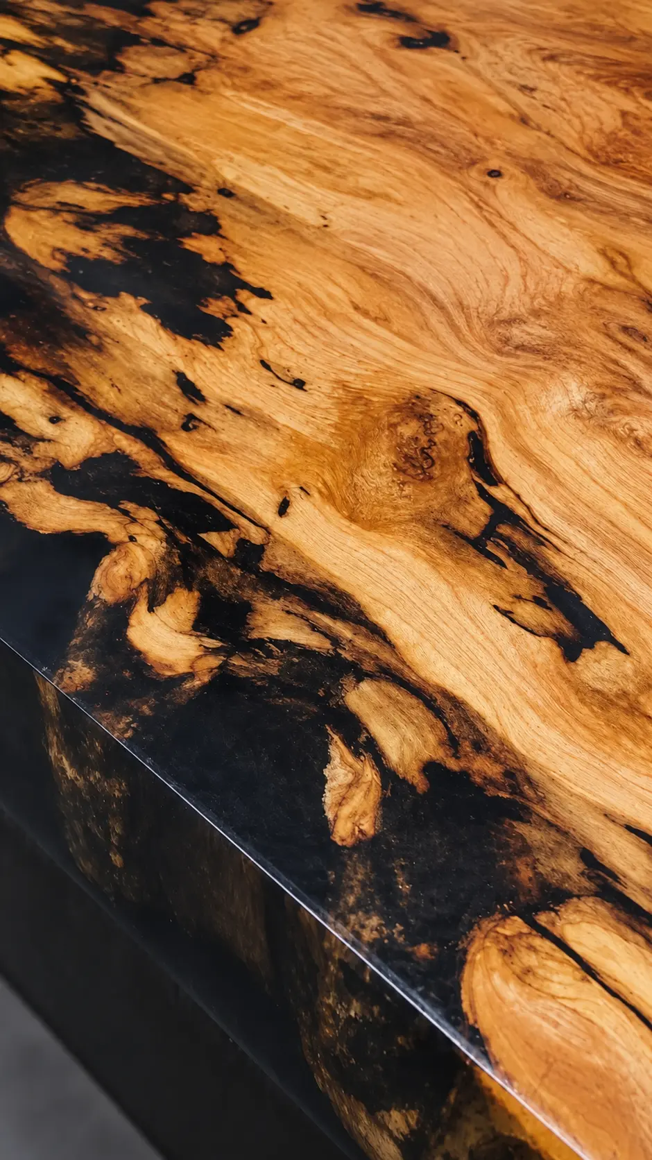 Detalle de madera de olivo natural con vetas oscuras y resina negra, mostrando la textura y el acabado de una superficie artesanal – Aluna Crafted