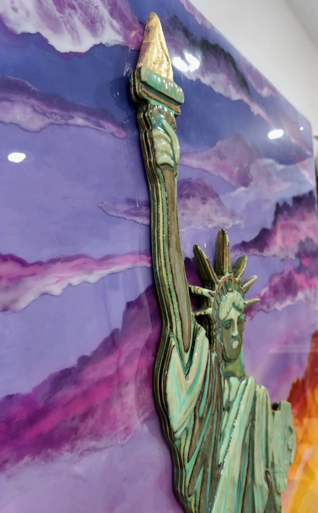 Detalle lateral antorcha Estatua de la Libertad en madera laminada con capas verdes y llama dorada, resina lila
