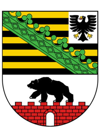 Wappen von Sachsen-Anhalt mit gelb-schwarzen Streifen, grüner schräger Rautenborte, schwarzem Adler in einem weißen Feld oben rechts, und schwarzem Bären auf roter Ziegelmauer auf weißem Grund unten.