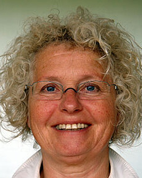 Irmela Boden mit lockigem grauem Haar und Brille lächelt frontal in die Kamera.