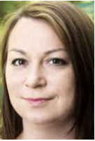 Porträt einer Frau mit langen braunen Haaren, die leicht lächelt, vor grünem Hintergrund.