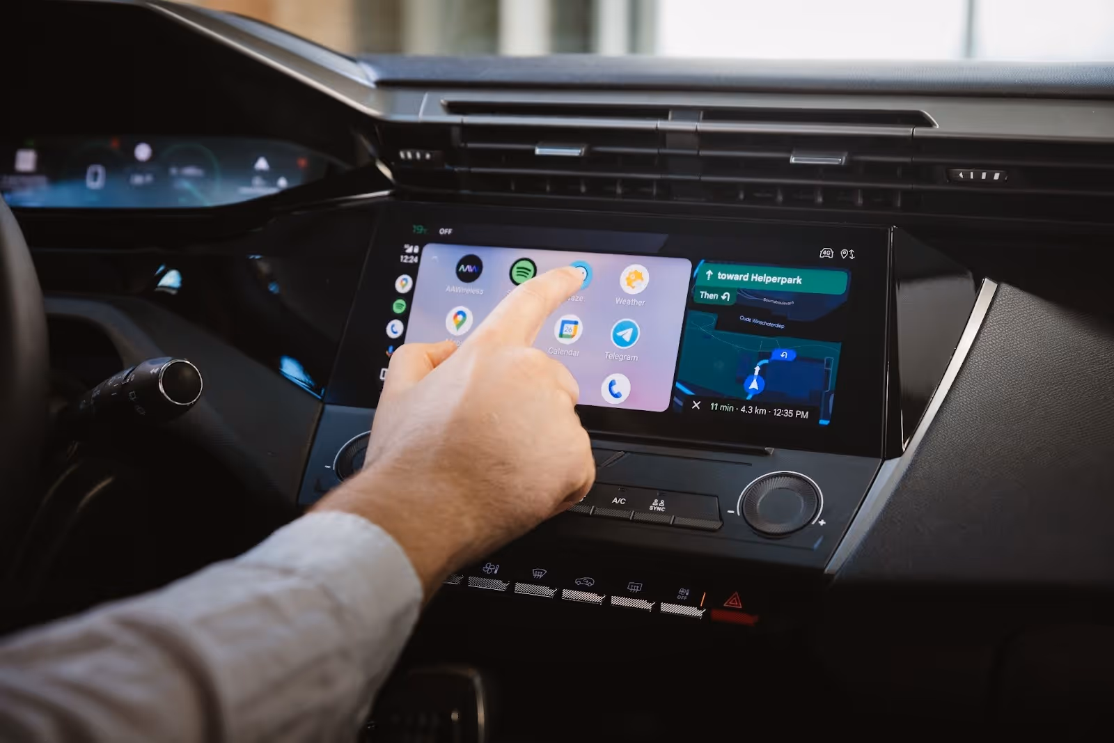hand pointing finger to Android Auto display on car dashboard