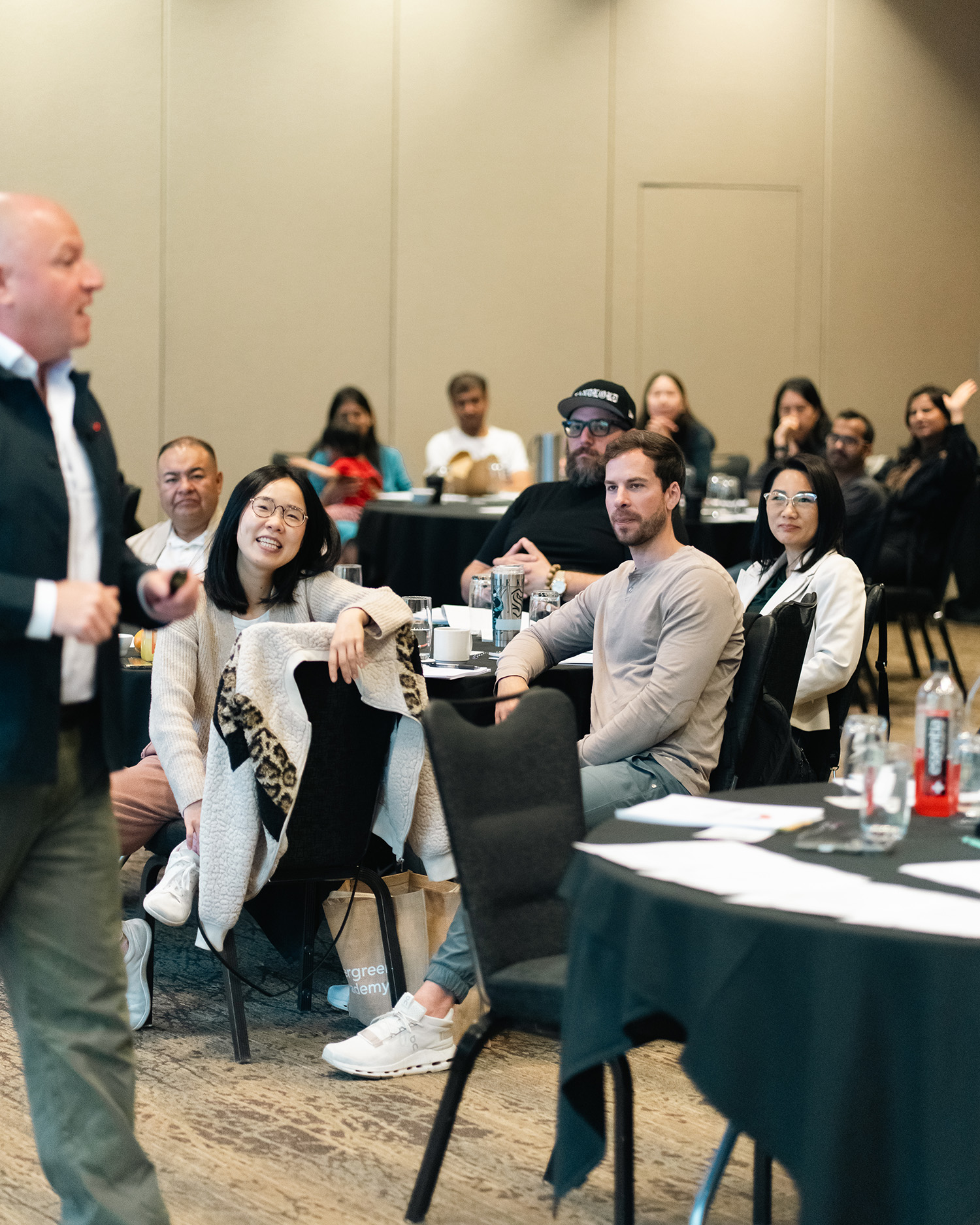 Marc Rousso speaking to an audience about The Life Business Plan. Large conference room with people sitting at tables in the round, smiling and engaged.