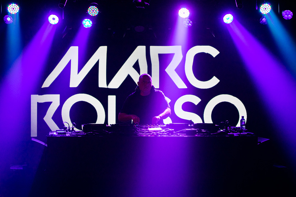 Marc Rousso DJ stage set with Marc on the turntables and Marc's name in lights in the background.