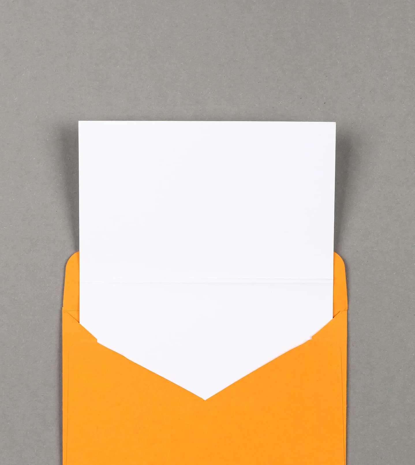 opened orange envelop with a blank sheet of paper pulled out