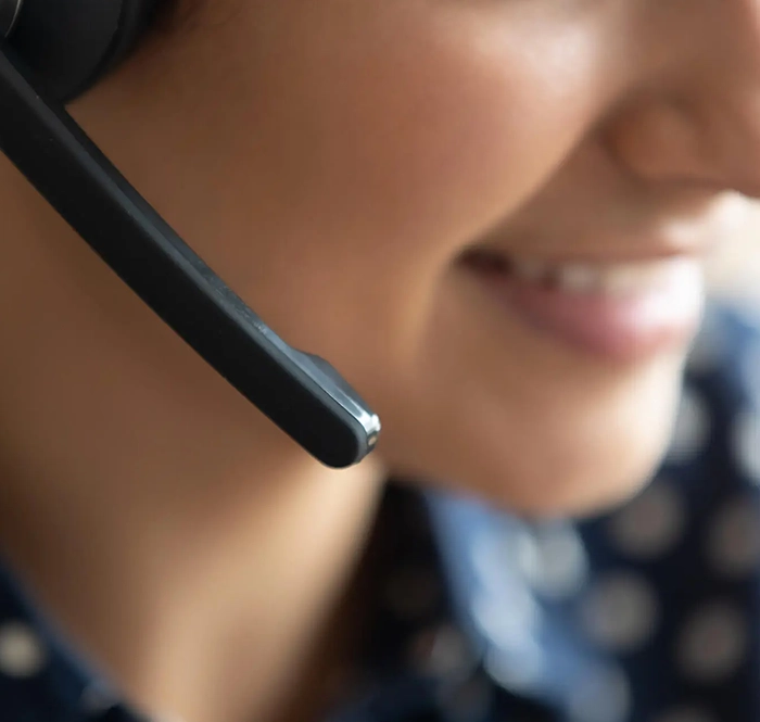 Close up of a telemarketing caller smiling and talking on a headset