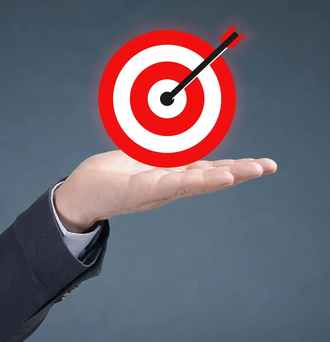 Grey background with a target board  held up by a business mens hand