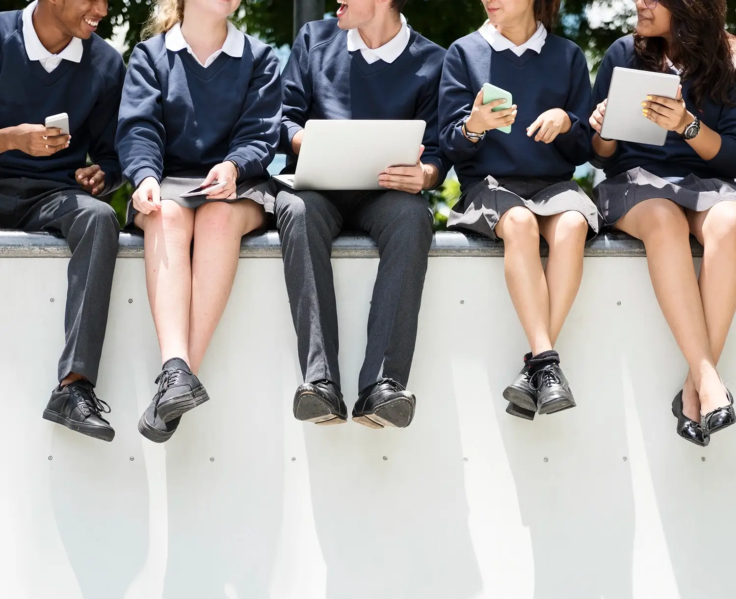 Close uo of school kids sitting on the wall