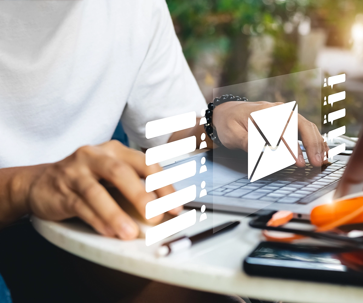 Man working on a laptop with hovering graphic logos in front of him