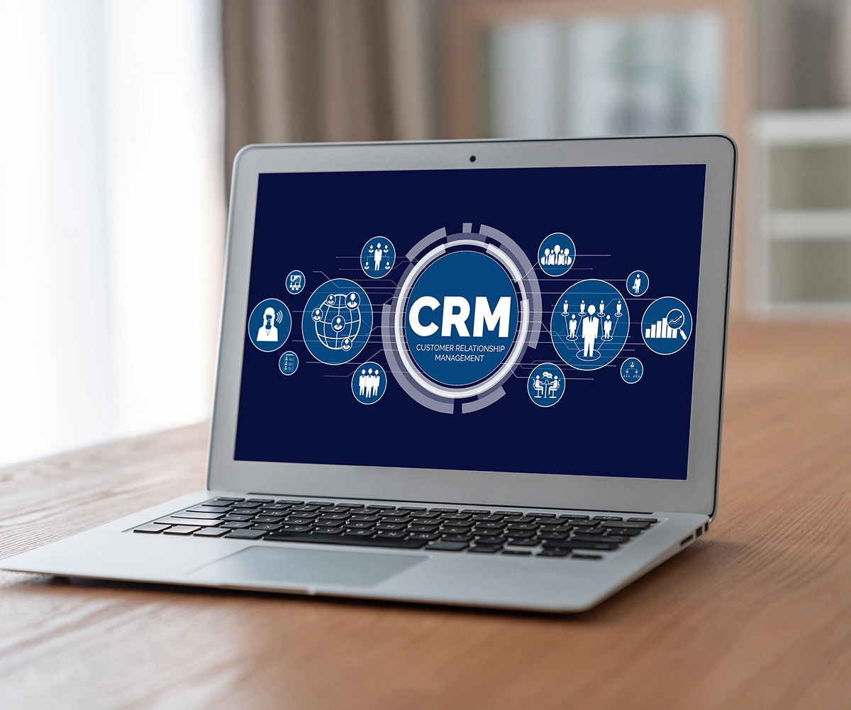 Image of a laptop with a graphic in the screen with text overlayed 'CRM'