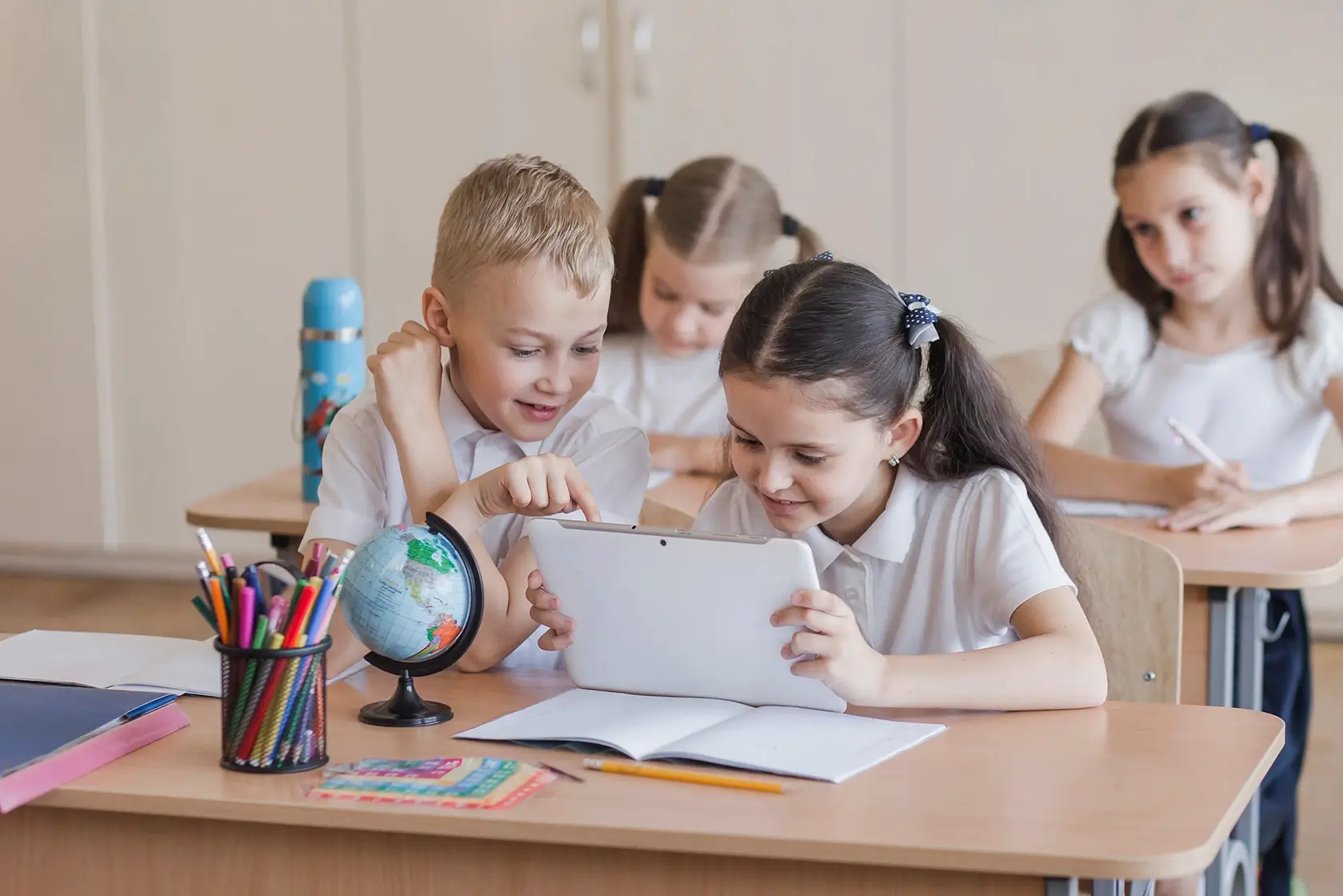 Class room of a young girls reading from a tablet