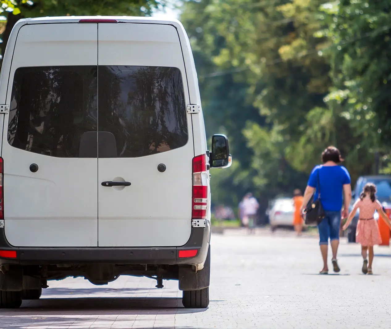 Back of a white mini-bus on a sunny day