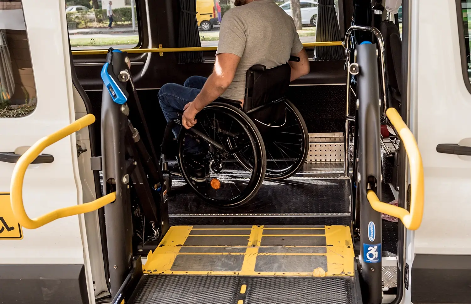 Close-up of a man in a wheel chair boarding a mini-bus with wheelchair access