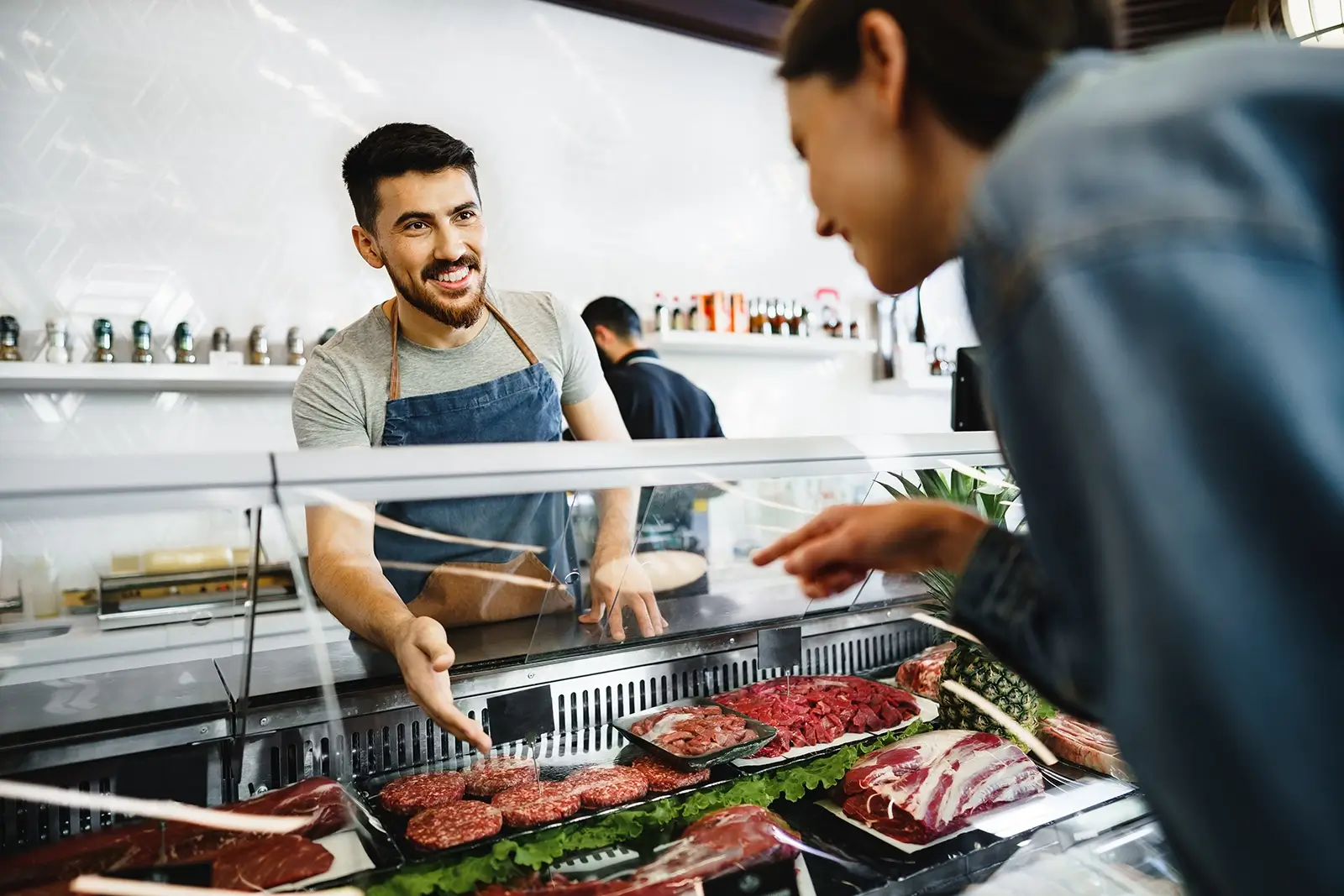 A customer choosing there cut of meat from the butchers