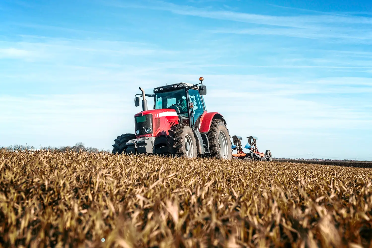 Tractor plowing a field of wheat