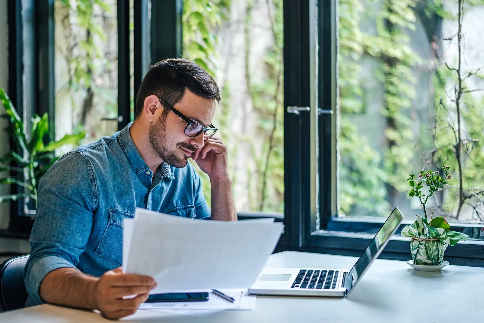 A young guy with glasses reviewing financial documents