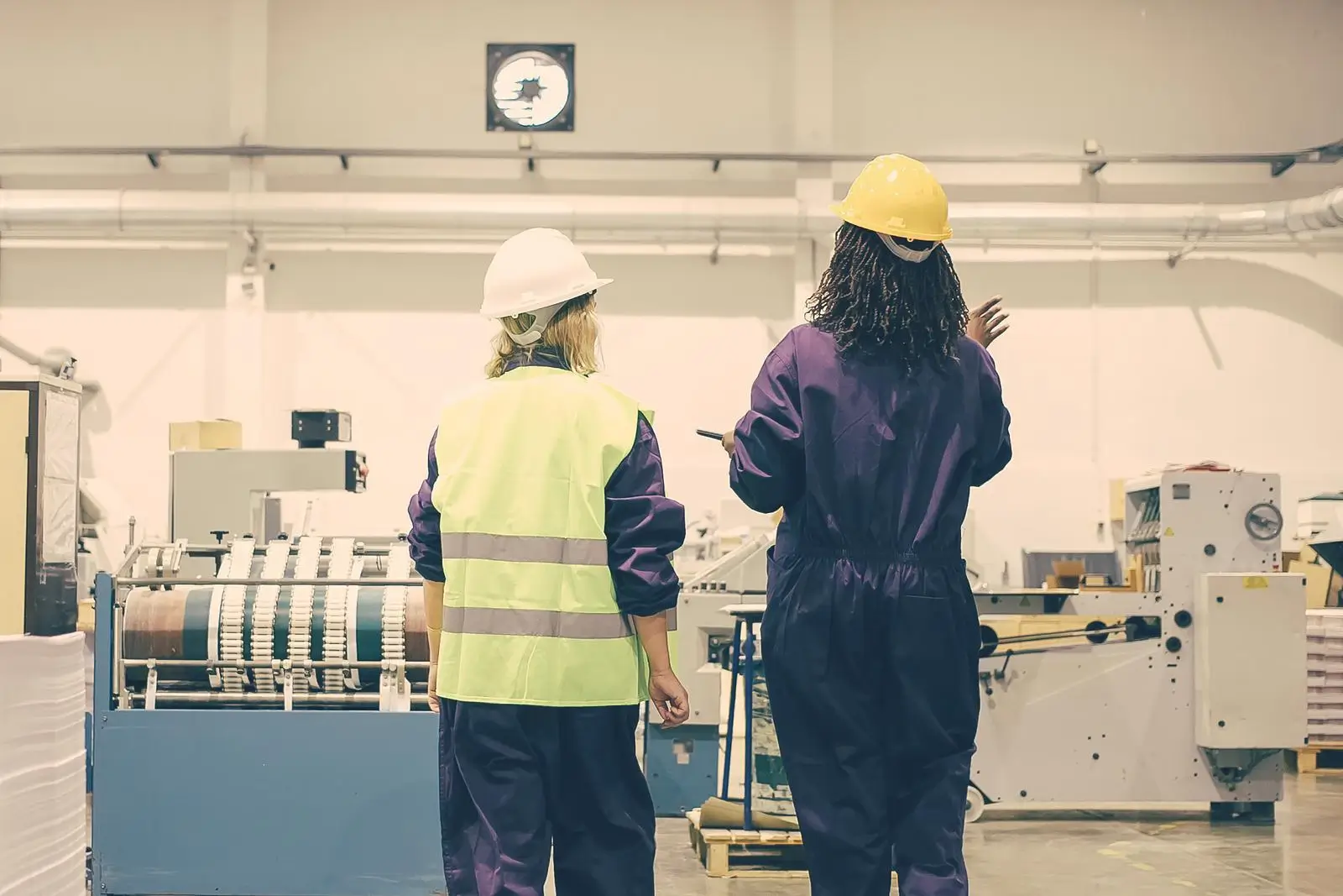 Back view of 2 manufacturing workers on the factory floor