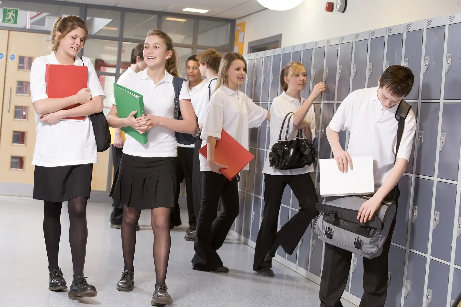 Teens In School Corridor walking through