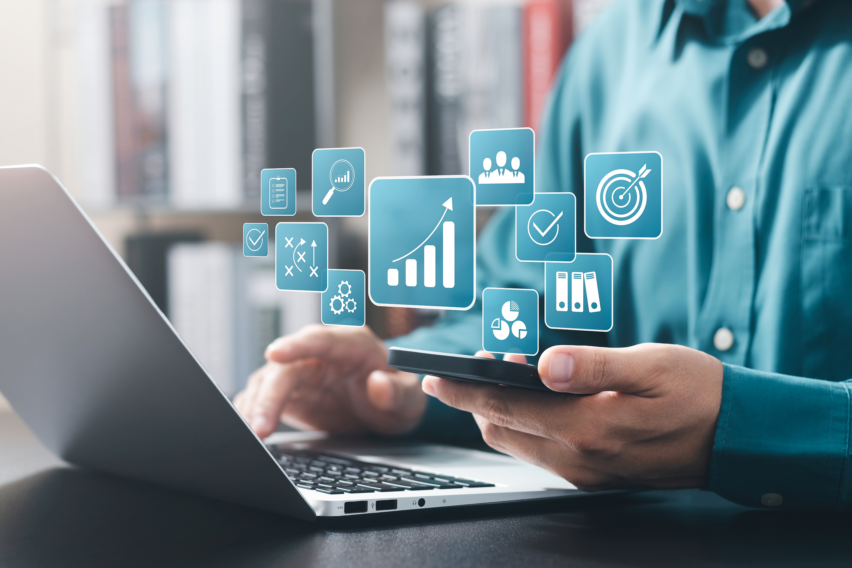 Close up of a employee working at a workstation with hovering graphical icons