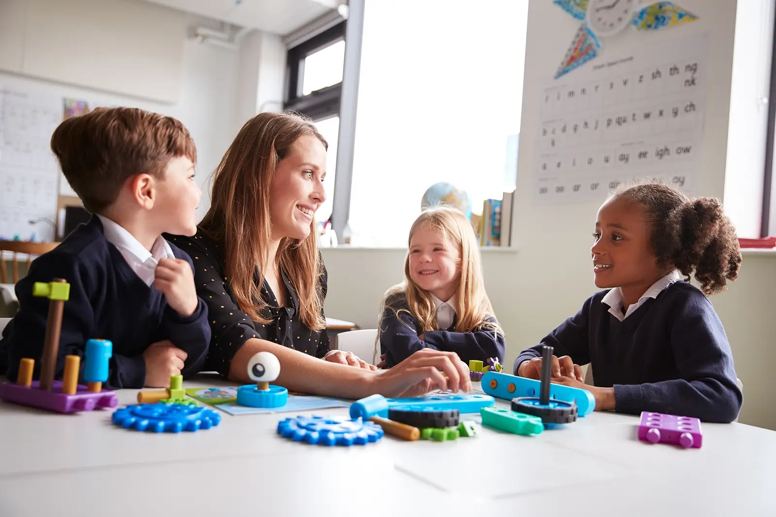 Female teacher and three primary school children