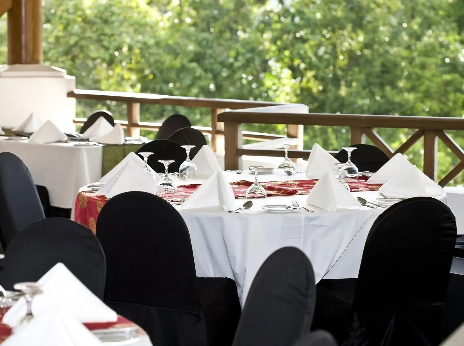 A empty restaurant with set out tables in a green backdrop