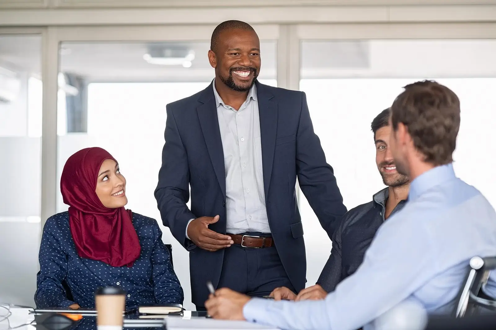 Smiling black man in a relaxed suit in a meeting