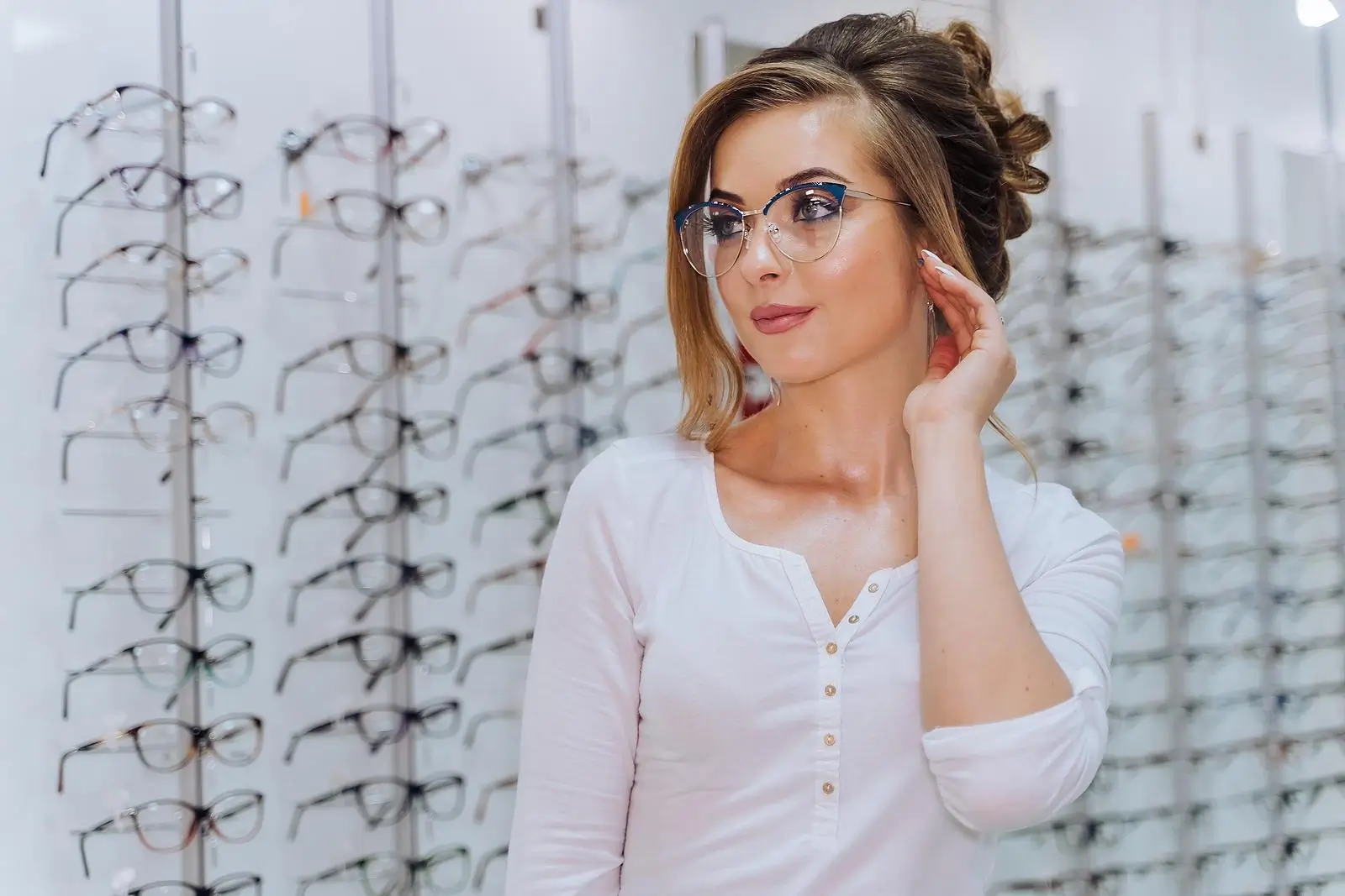 Young women trying on new glasses frames