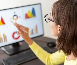 Close-up of a women point to a dashboard presenting analytical data