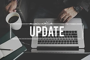 Birds-eye view of a business men working on his laptop with the text 'UPDATE' overlayed