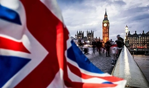 Close-up view of the UK union jack flag with the Houses of Parliament in the background