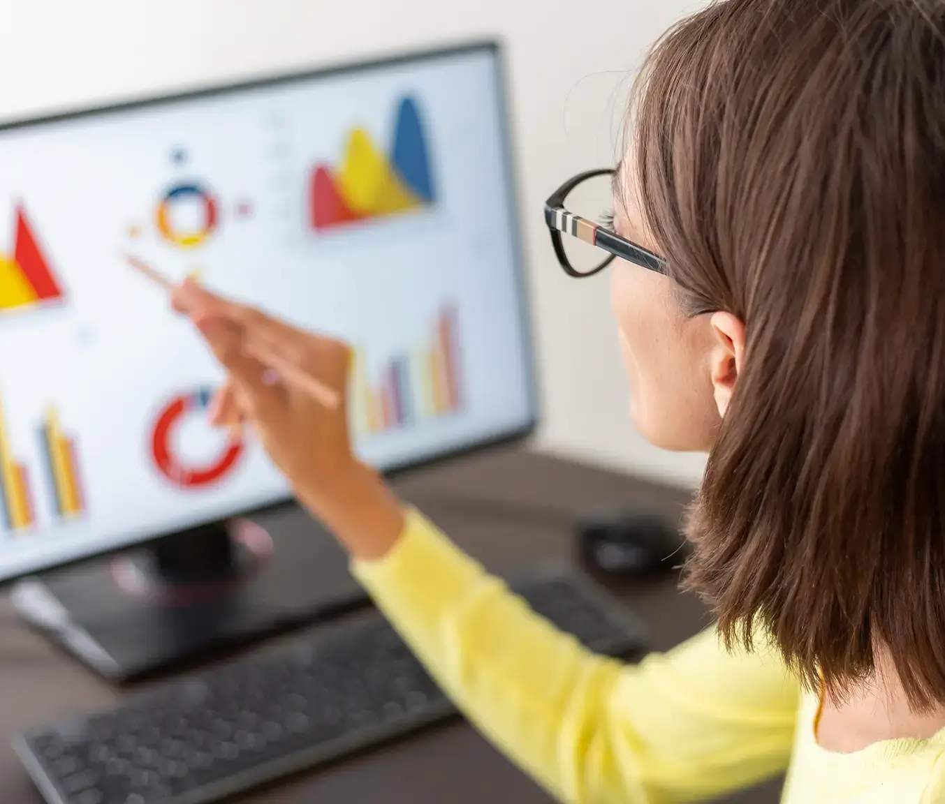 Close-up of a women point to a dashboard presenting analytical data