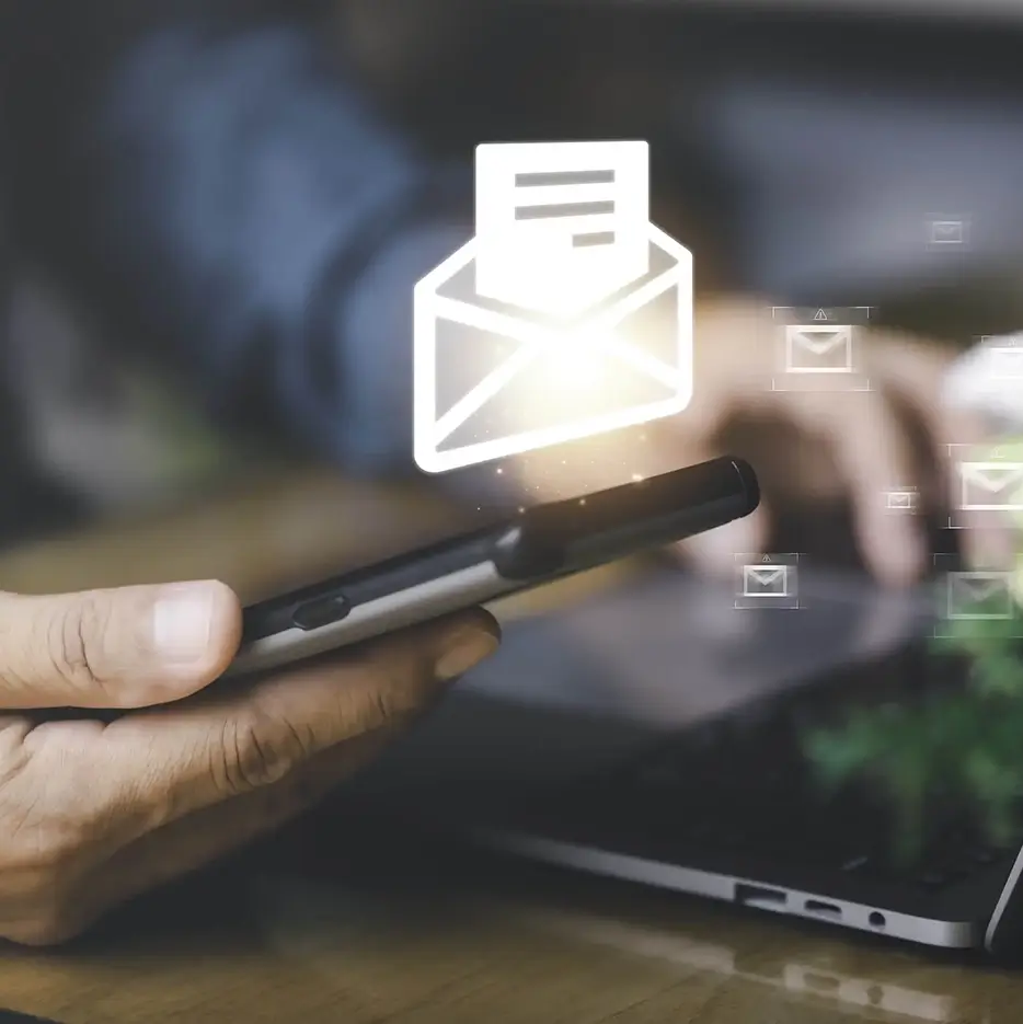Close-up of a businessmen viewing his mobile phone with a email vector icon floating above it