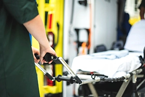 Close up of a ambulance crew with a patent trolley with a an ambulance in the background