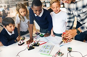 Group of diverse school kids in a classroom with a teacher