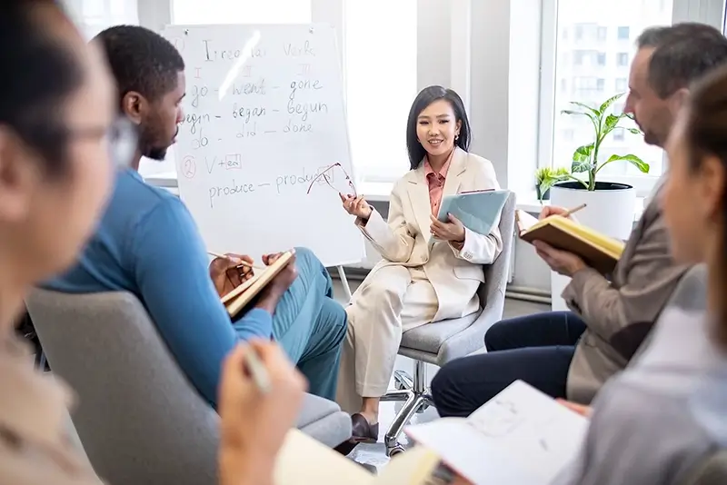 Asian women leading a presentation with work colleagues