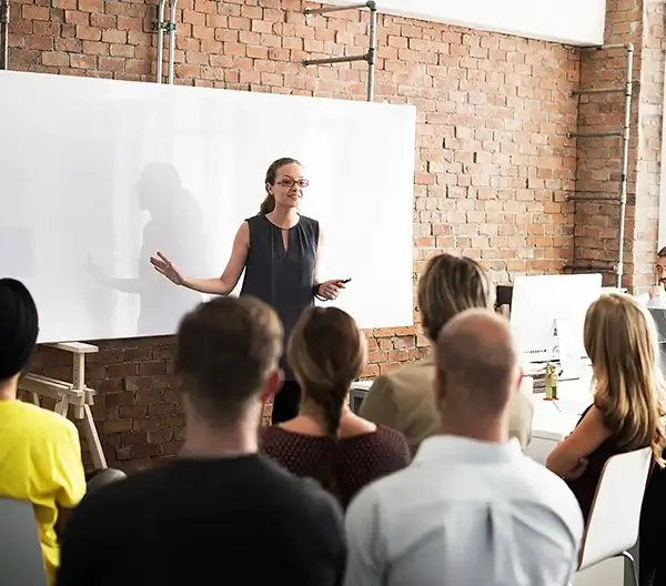 A women is leading a presentation in a office with colleagues